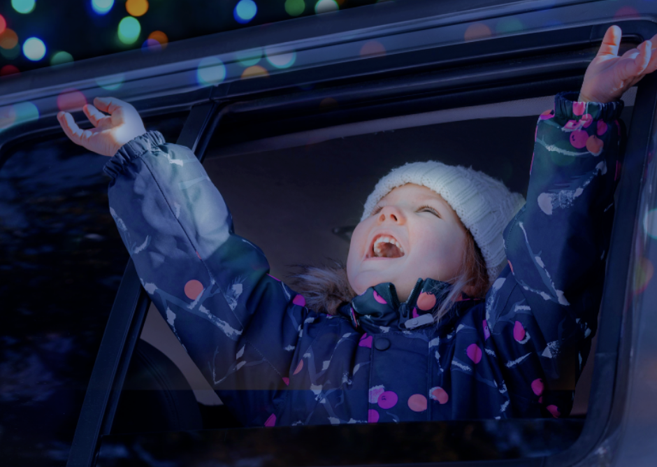 Young person enjoying the Christmas Lights in Lincoln Nebraska events from the window of a car.